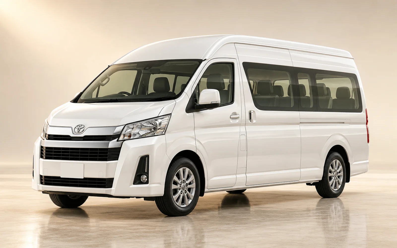 White Toyota Hiace passenger van, front three-quarter view in a warm studio. Illustrative model reference, not a photograph of an H&R Executive Services vehicle.